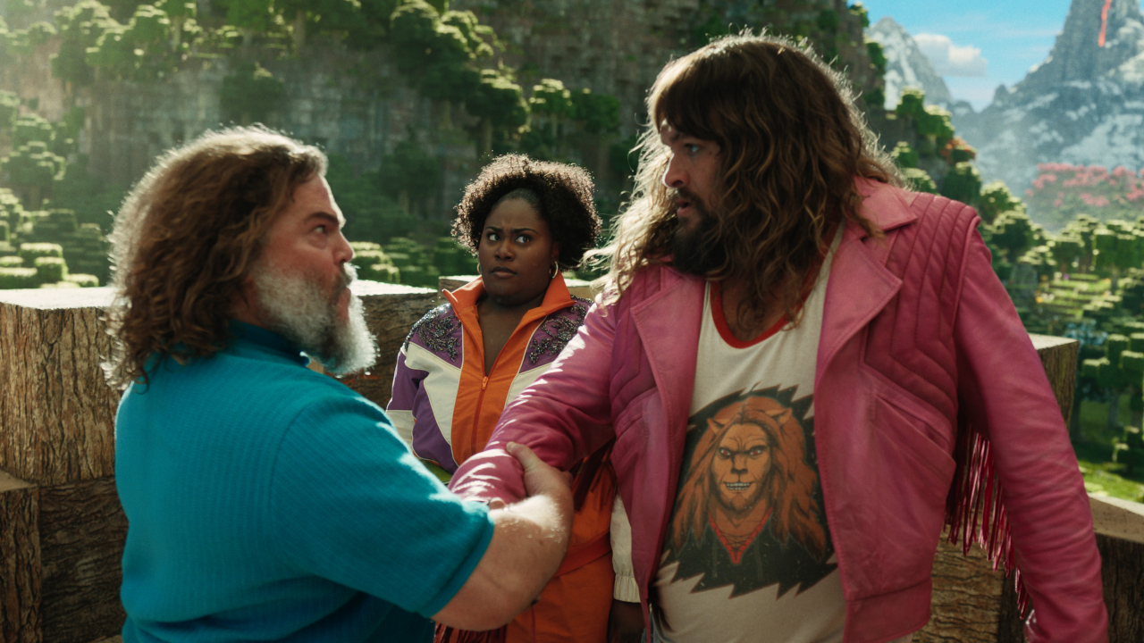 Danielle Brooks shoots a confused look at Jack Black and Jason Momoa clasping arms in A Minecraft Movie.